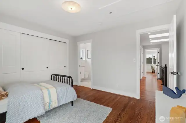 Looking from the third upstairs bedroom into the Jack & Jill bathroom and out to the hallway, this perspective highlights the thoughtful layout and seamless flow between spaces. Not pictured is the room’s access to the west-facing deck, which offers views similar to those enjoyed from the adjacent office or nursery.