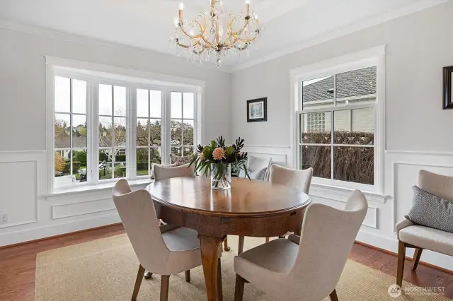 A 1930s-era Massive brand crystal chandelier anchors the coffered ceiling, offering a dramatic focal point. Custom-designed wainscoting adds depth and character, while the bespoke bow window features a polished quartzite inlay—an elegant blend of craftsmanship and timeless materials.