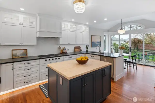 The kitchen features double undermounted Rohl sinks paired with Grohe polished chrome pull-down faucets—one with convenient touch activation—for a seamless blend of style and function. Over the kitchen table hangs an antique milk glass light from Rejuvenation Hardware, originally from the historic Drake Hotel in Portland, adding a touch of vintage charm to the space.