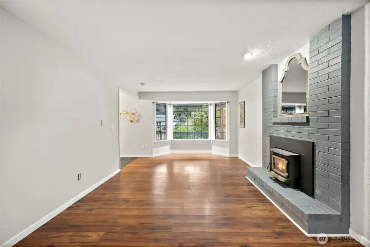 Bay window perfect for a reading area and enough space for a cozy family room set up by the fireplace.
