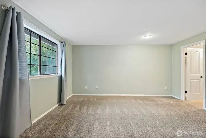 Primary Bedroom with a window looking out to front yard and bringing in the morning light