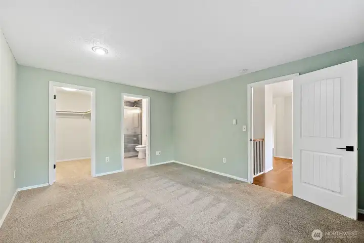 Primary suite with carpeted flooring, featuring a walk-in closet, en-suite remodeled 3/4 bath