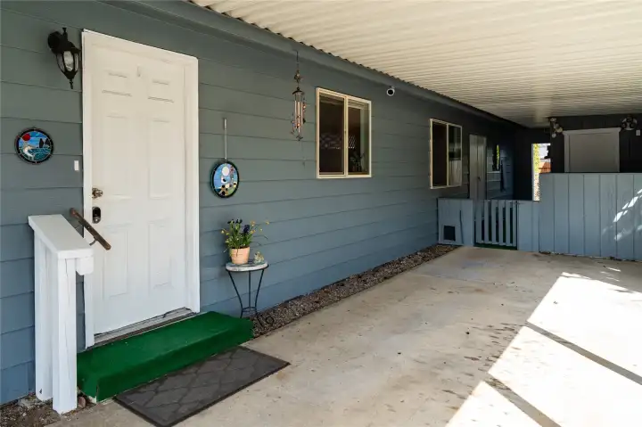 Carport, door to laundry, storage room and workbench in the back of carport.
