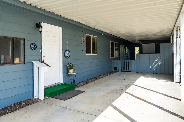 Carport, door to laundry, storage room and workbench in the back of carport.