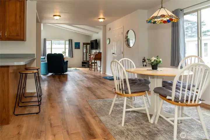 View from hallway. Kitchen on left. Dining & front door on right. Living room in back.