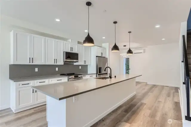 ***UNIT B Actual Kitchen - custom quartz countertops and black pendant lighting.