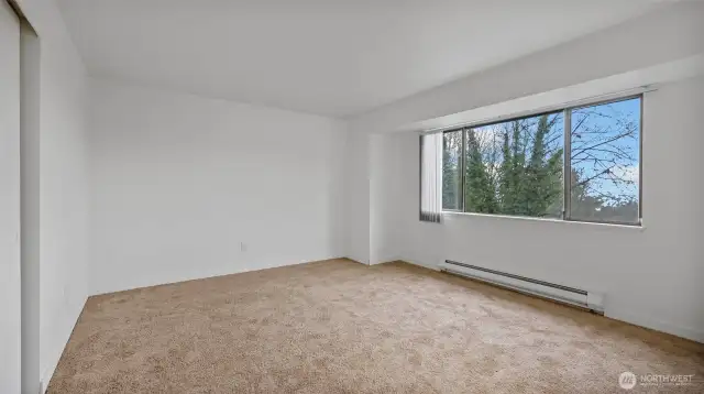 Another angle of the primary bedroom showcasing the abundance of natural light.
