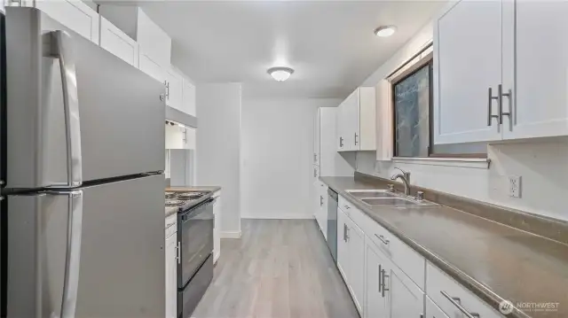 Kitchen with white shaker cabinetry & ample counter space as well as storage.