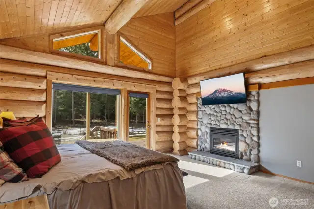 Primary bedroom with fireplace and access to back deck.