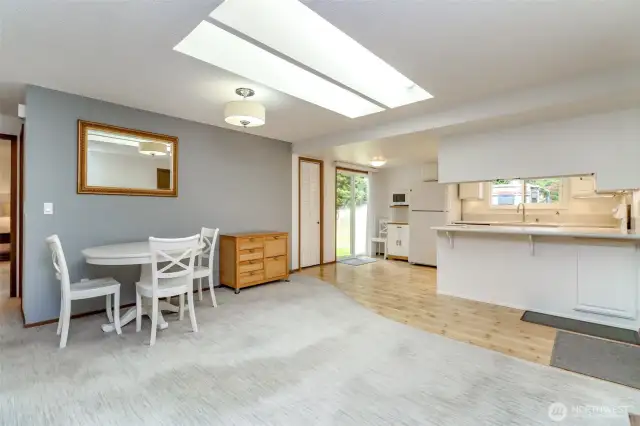 Here you see the dining area, the huge skylight, quality Pergo flooring in the kitchen, the breakfast bar and door to the back yard. No furniture is left in the house. Photos were taken prior to the seller moving.