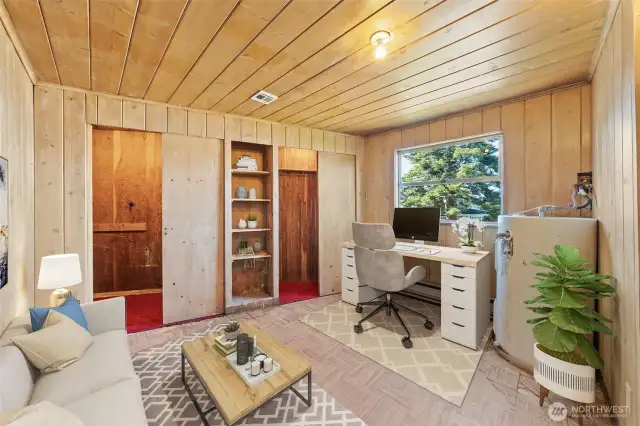 The first bedroom is virtually styled as a functional home office, featuring built-in shelving and ample storage—perfect for work, hobbies, or creative space.