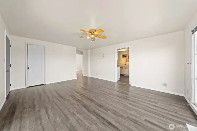 The open layout provides flexible options for furniture arrangements and seamless flow into the kitchen, with the added convenience of a side entrance to the yard and a storage closet.