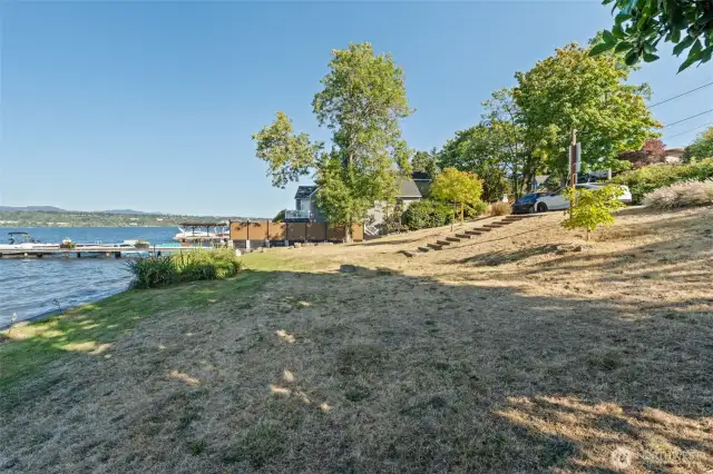 Gently sloped lawn leading to the shoreline, perfect for lakeside lounging and enjoying the outdoors.
