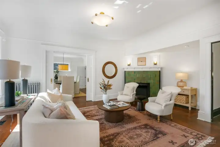 Living room boasts original tile fireplace and pocket doors to the dining room