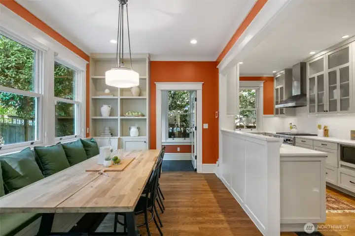 Natural light floods the kitchen through a wall of windows, highlighting its generous scale and functional design.