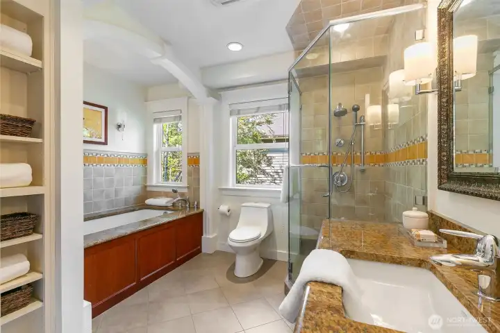 A generously sized hallway bath features both a soaking tub and separate shower