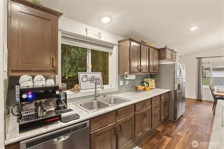 Kitchen sink positioned under window with dedicated space for coffee or prep station.