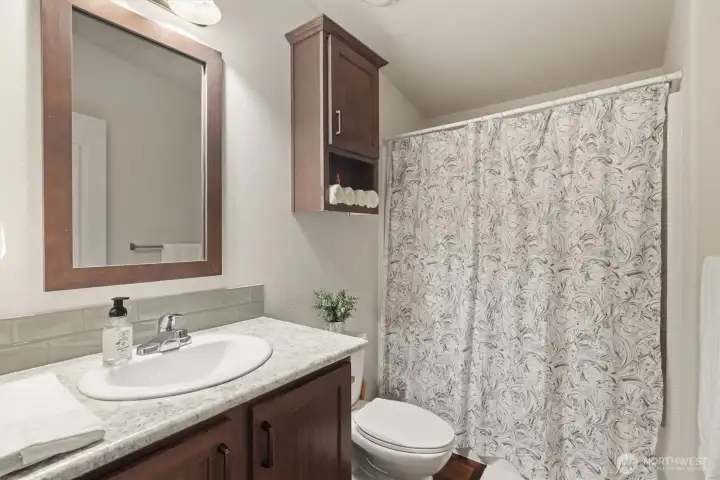 Full guest bathroom with storage and clean, functional layout.