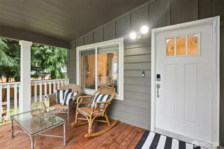 Covered front porch designed for everyday use—comfortable, private, and connected to the surrounding greenery.
