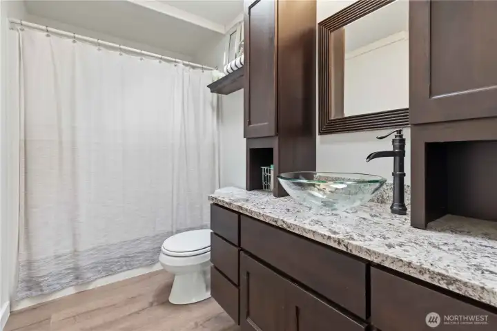 Guest bathroom is complete with tub, new flooring, new vanity and fresh paint.