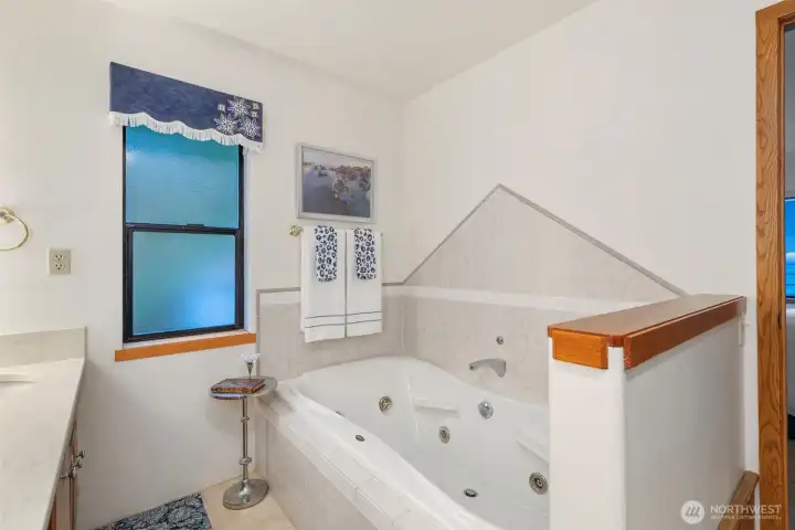 Main level primary suite has a relaxing 5 piece bath with jetted soaking tub. Main level primary suite has a relaxing 5 piece bath with jetted soaking tub.