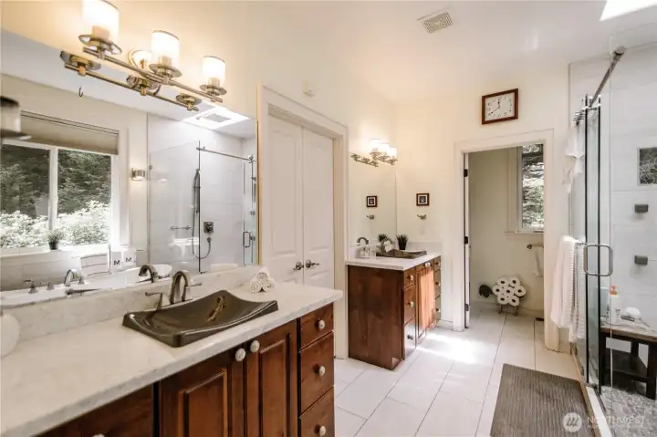 Dual vanities in the primary bath with a private commode.