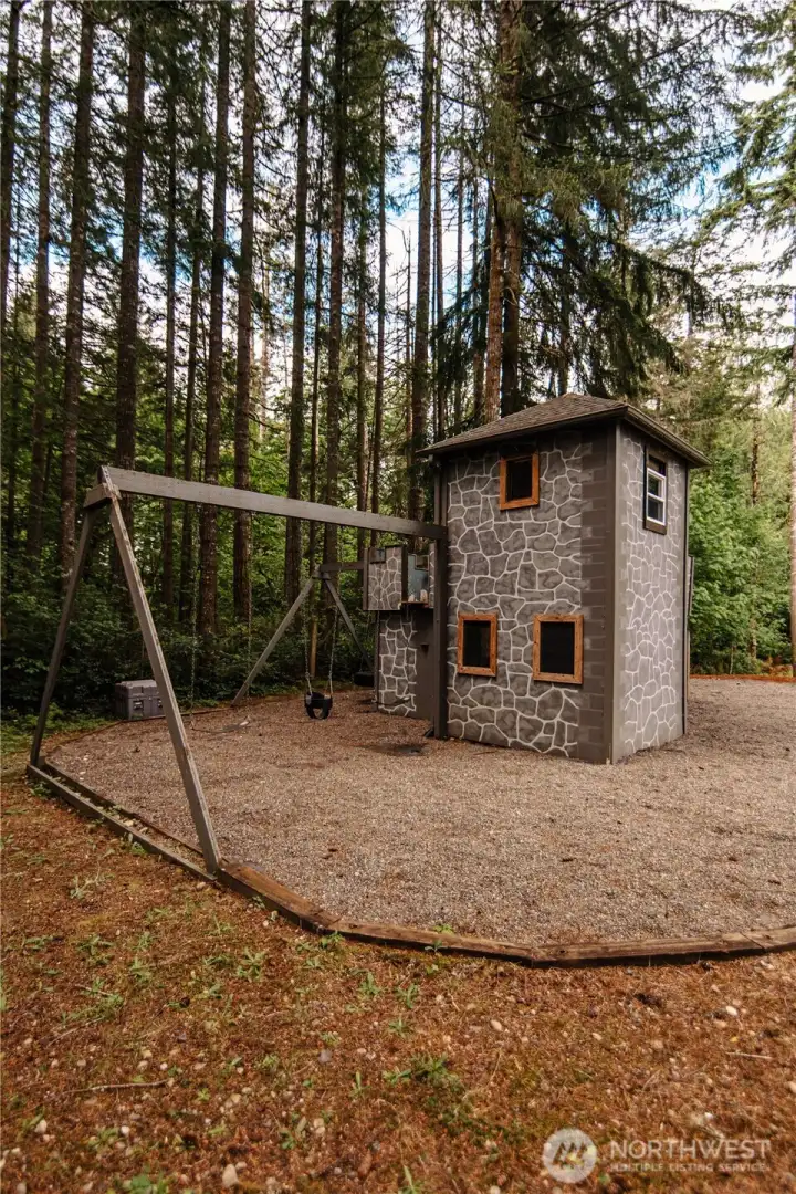 Castle inspired play structure with swingset.