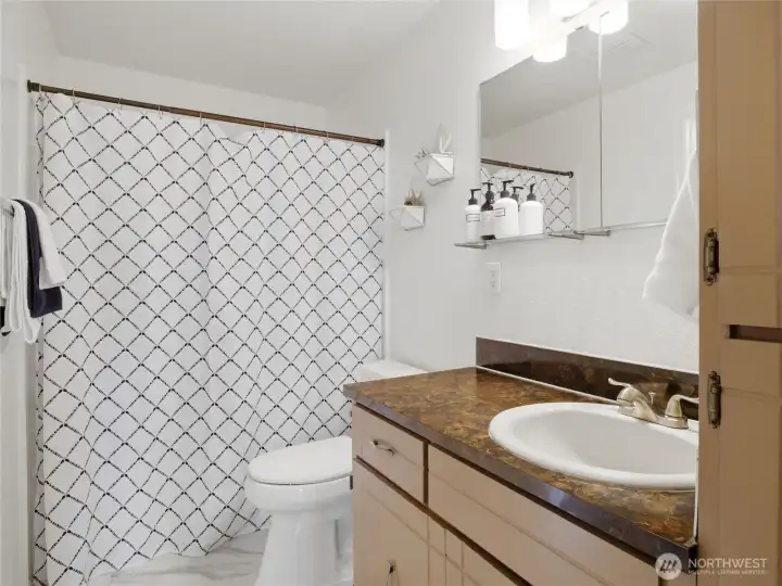 Refreshed bathroom- new flooring, faucets, light and tub surround.