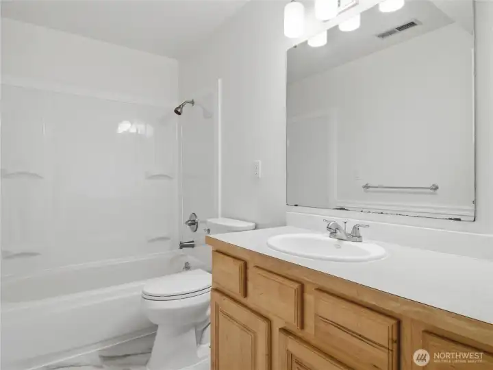New tub surround, flooring, faucets and light.