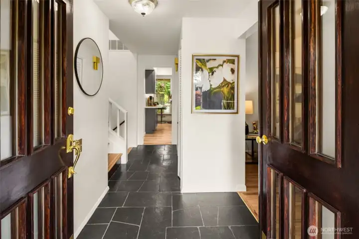 Welcoming entry with slate flooring and refinished stairway.