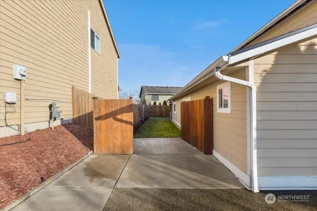 Double width gate, making it easy to store things behind the fence! You'll notice the extended driveway and path, which may afford parking for more than 2 vehicles, depending on the size