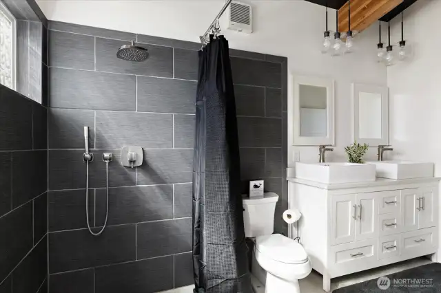 Thoughtful details like Pottery Barn mirrors, West Elm lighting, a high John toilet, and a tankless water heater complete the spa-like feel. This picture is the Primary Bathroom #1.