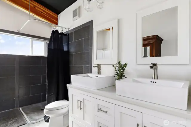 Indulge in the Ferguson Grohe tile-surround shower, quartz vanity, Ronbow ceramic sink, and soft-close cabinetry.