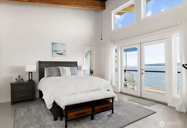Second Primary Bedroom mirrors the first, with spacious features and wide closets with double-high shelving, a vaulted ceiling, also with French doors to the deck.