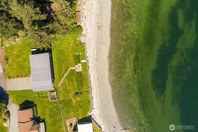 With tidelands hosting an active oyster farm included! See the Oyster farm in the dark shadow closest to the beach in front of the home.