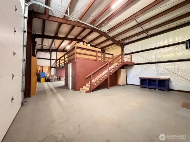 Staircase up to a loft area. Storage room or office through the white door next to the stairwell.