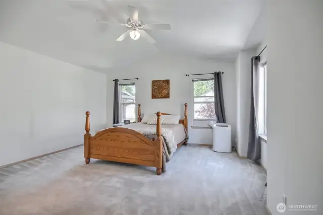 The spacious primary bedroom has vaulted ceilings.