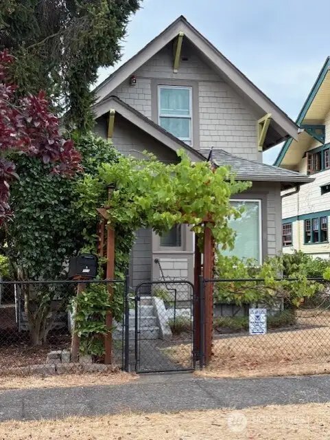 Grape arbor and ornamental cherry adorn the front entrance, with a view to the gorgeous rose garden next door!