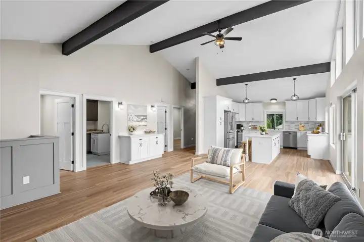 Warm modern furnishings anchor the great room with the kitchen beyond