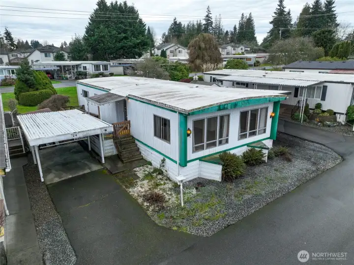 Home #24 with covered carport, plus additional driveway parking.  One more parking space behind back deck and storage shed is beyond the carport.