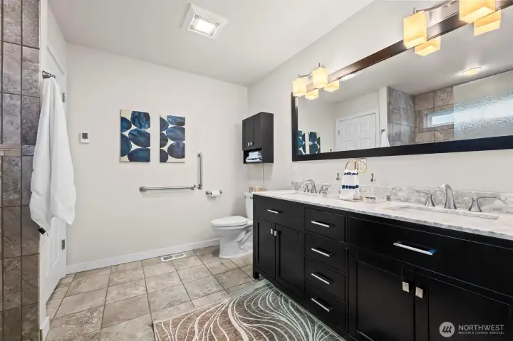 Door in bathroom opens to a full closet and removable panels to access the tankless water system.