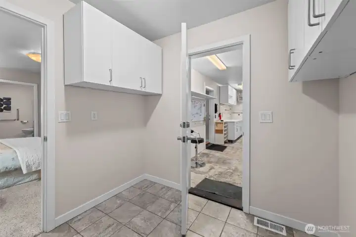 Cabinetry is on both sides of laundry room.