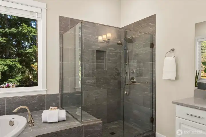 Fully tiled shower with a convenient bench and nice. Upgraded glass enclosure. Resort style shower experience with a rain shower head and handheld sprayer.