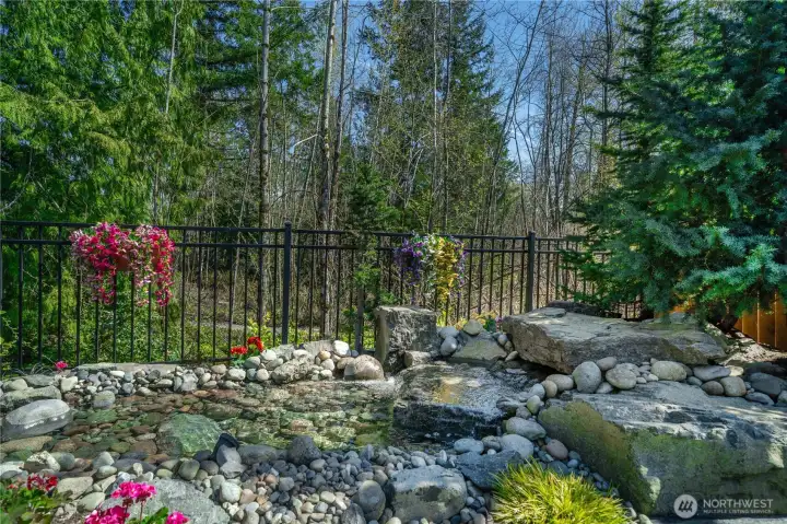 The amazing water feature nestled against the treed backdrop will delight!