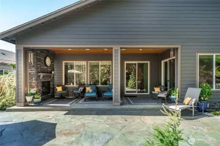 The amazing rear covered patio with a custom stone fireplace, stained wood ceiling and surround sound. Extensive Flagstone and generous spaces.