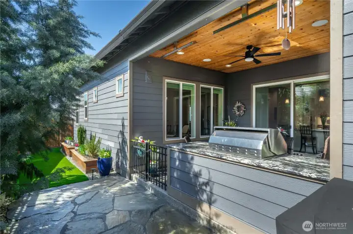The outdoor covered patio off of the kitchen is truly an extension of the living space. Complete with an outdoor kitchen w/ grill, fridge and drawers and granite counter. The patio was raised so no step, stained wood ceilings, Bromic heaters and surround sound. More high-grade turf and raised planter beds with irrigation.