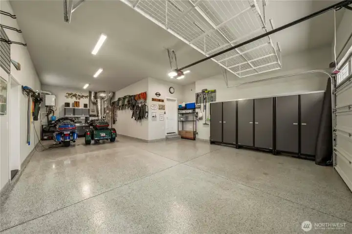 This pristine painted & fully insulated three car garage offers epoxy floors, tons of storage, a work bench, EV outlet, flow wall attachments, battery backup for garage door opener, a man door & outdoor outlet to connect generator to electrical panel.