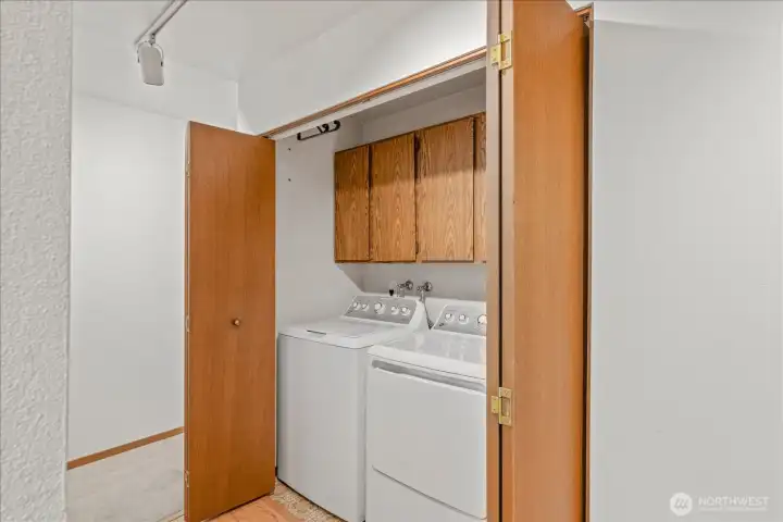 In unit laundry with storage cabinets make daily chores a breeze