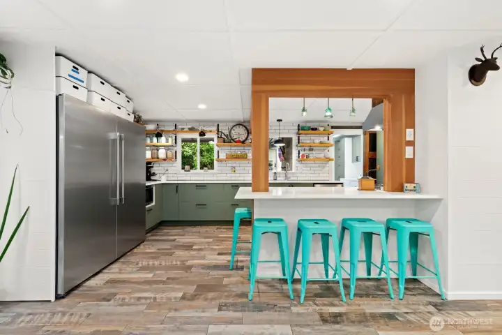 Eat-in kitchen with quartz counter top.  Extra-Large two-door refrigerator/freezer stays with the home!  White subway tile is easy to clean.  Fun open shelving for easy access to dishware.