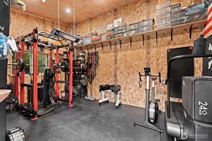 Heated outbuilding near deck has been set up as weight room.  Could also be home office space or play room.